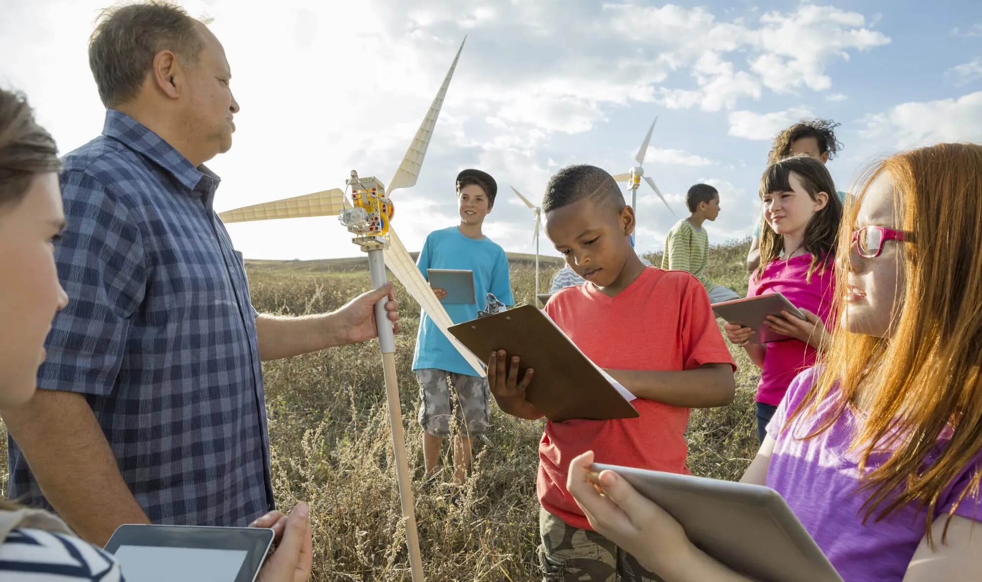 teacher conducting an outdoor class with students taking notes